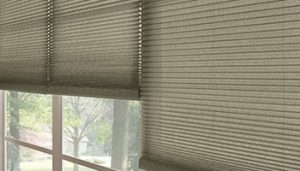 Olive coloured cellular shades with one half open.