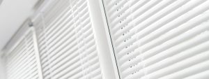 Close up of three windows with white blinds.